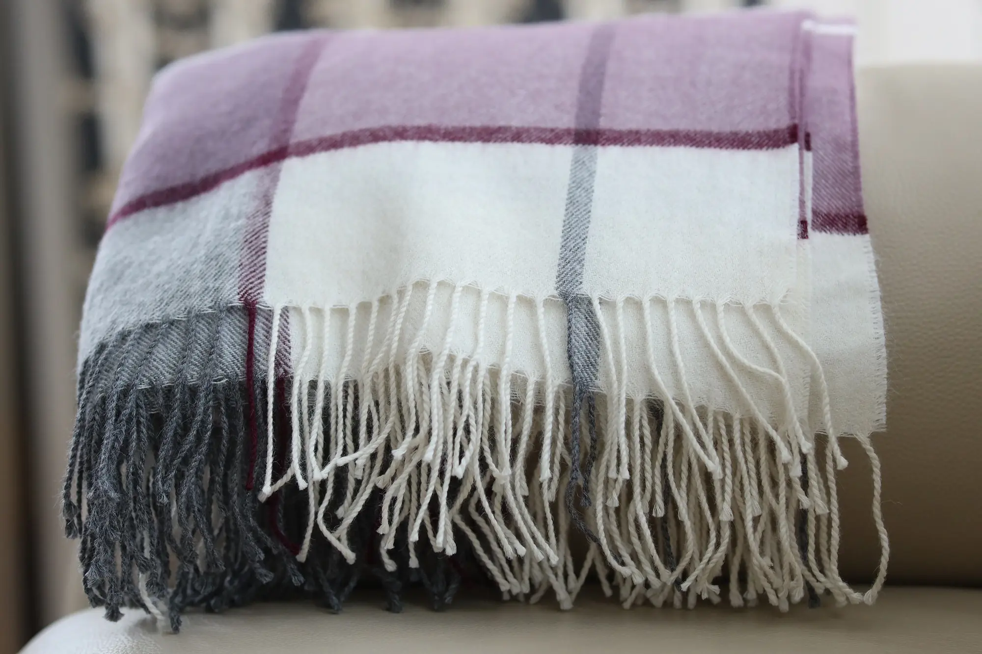 Gefaltetes Baby Alpaka Plaid auf Sessel – weiche Fransen und luxuriöse Textur